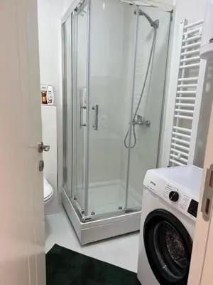 a bathroom with a shower and a washing machine at GreenCity10 in Belgrade