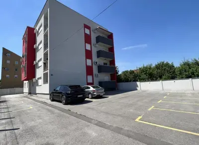 a car parked in a parking lot in front of a building at GreenCity10 in Belgrade