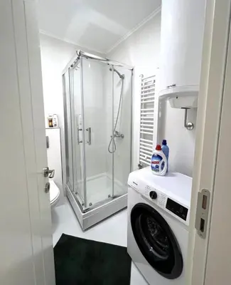 a bathroom with a shower and a washing machine at GreenCity10 in Belgrade