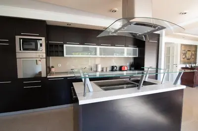 a kitchen with black cabinets and a stainless steel sink at Sweet House Parlament Lux in Belgrade
