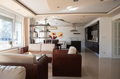 a living room with two couches and a kitchen at Sweet House Parlament Lux in Belgrade