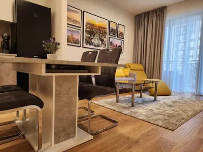 a living room with a table with a television at Ramonda Belgrade Waterfront - BW Aqua in Belgrade