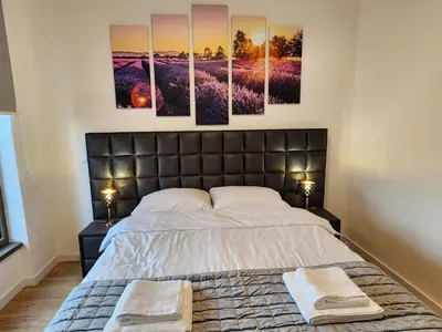 a bedroom with a bed with four paintings on the wall at Ramonda Belgrade Waterfront - BW Aqua in Belgrade
