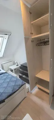 a bedroom with a bed and an open closet at Privatna soba Marijana-Olja in Surčin