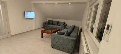 a living room with two couches and a table at Privatna soba Marijana-Olja in Surčin