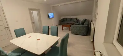 a living room with a white table and green chairs at Privatna soba Marijana-Olja in Surčin