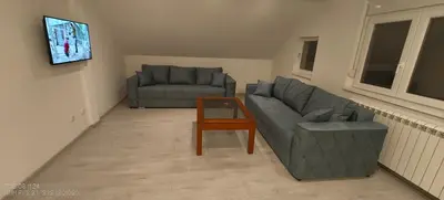 a living room with two couches and a coffee table at Privatna soba Marijana-Olja in Surčin