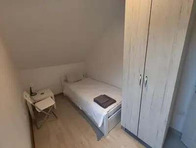 a small bedroom with a bed and a cabinet at Privatna soba Marijana-Olja in Surčin