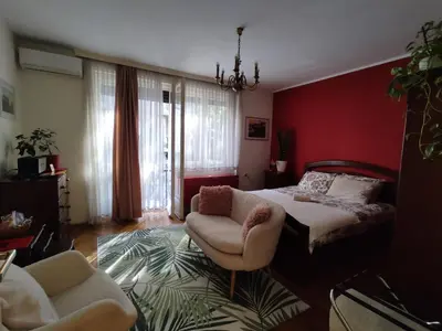 a bedroom with a bed and a couch and a chair at BGholik studio apartment in Belgrade
