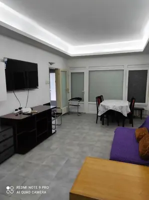 a living room with a tv and a couch and a table at Fair and Share Apt 1-7 guests in Belgrade