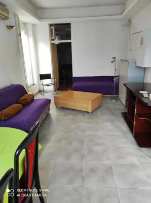 a living room with purple beds and a table at Fair and Share Apt 1-7 guests in Belgrade