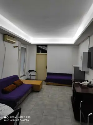 a large room with purple beds and a tv at Fair and Share Apt 1-7 guests in Belgrade
