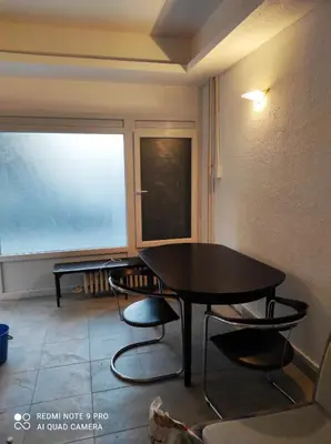 a table and chairs in a room with a window at Fair and Share Apt 1-7 guests in Belgrade