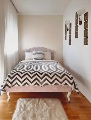 a bedroom with a bed with a black and white comforter at Antik Apartman in Stara Pazova