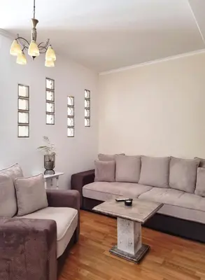 a living room with a couch and a table at Antik Apartman in Stara Pazova