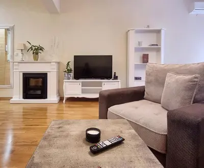 a living room with a couch and a television at Antik Apartman in Stara Pazova