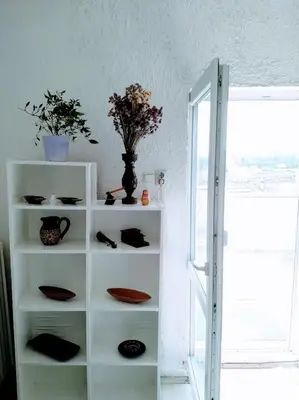 a white shelf with plates and a vase with flowers on it at Belgrade River view 1 in Belgrade