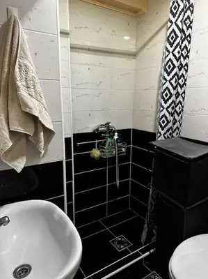 a black and white bathroom with a sink and a toilet at Cozy loft in Belgrade