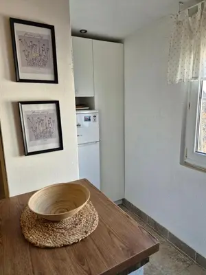 a kitchen with a wooden bowl on a wooden table at Sweet House Parlament in Belgrade