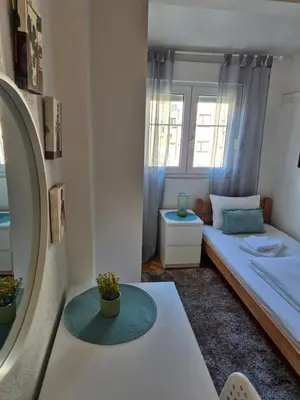 a small room with a bed and a window at Sweet House Parlament in Belgrade