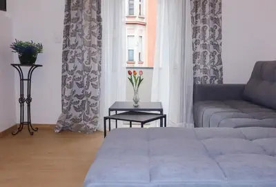 a living room with a couch and a table and a window at Audrey apartment Belgrade in Belgrade