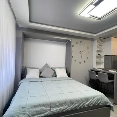 a bedroom with a bed with a clock on the wall at Apartman Film City in Žarkovo