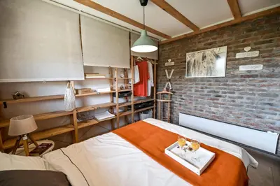 a bedroom with a bed and a brick wall at Top - kuća za odmor in Bukovik