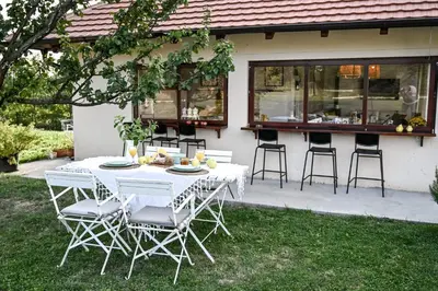 a white table and chairs in front of a house at Top - kuća za odmor in Bukovik