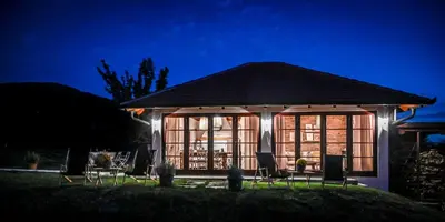a gazebo with chairs and windows at night at Top - kuća za odmor in Bukovik