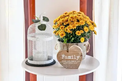 a table with a vase of flowers and a bird cage at Top - kuća za odmor in Bukovik
