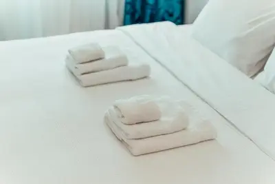 two folded towels sitting on a white bed at Biarritz Luxury Apartments in Belgrade