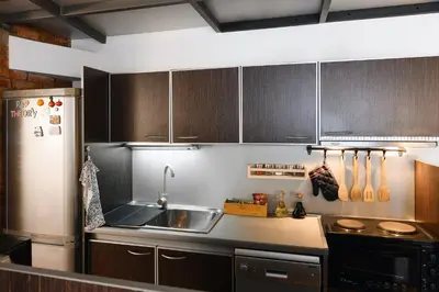 a kitchen with wooden cabinets and a stainless steel refrigerator at Family Penthouse with Terrace 5min to Kalemegdan in Belgrade
