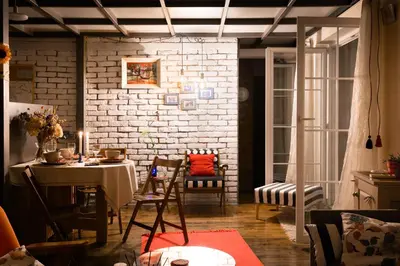 a dining room with a table and a brick wall at Family Penthouse with Terrace 5min to Kalemegdan in Belgrade