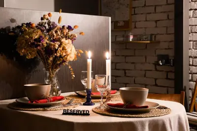 a table with two candles and a vase of flowers at Family Penthouse with Terrace 5min to Kalemegdan in Belgrade