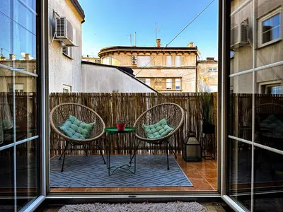 a view of two chairs and a table from a window at Family Penthouse with Terrace 5min to Kalemegdan in Belgrade