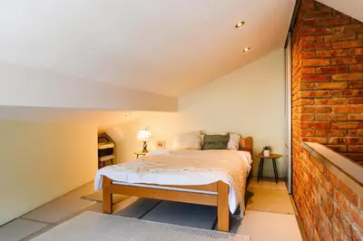 a bedroom with a bed and a brick wall at Family Penthouse with Terrace 5min to Kalemegdan in Belgrade