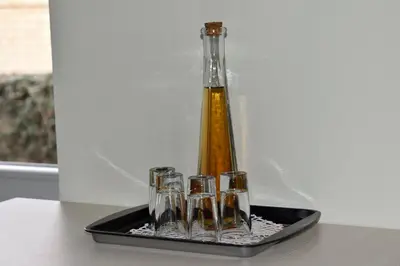 a tray with a bottle and four wine glasses at AeroVista Apartment in Surčin