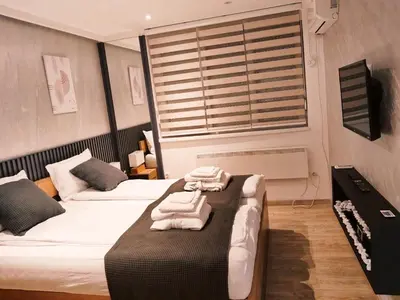 a bedroom with two beds with towels on a table at Apartman Premijer 1 in Čukarica