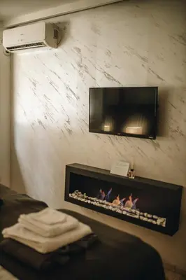 a living room with a fireplace with a tv above it at Apartman Premijer 1 in Čukarica