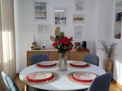 a dining room table with two plates and a vase with flowers at BeoCity 011 in Novi Beograd