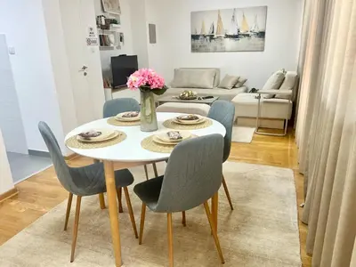 a dining room with a white table and chairs at BeoCity 011 in Novi Beograd