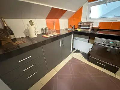 a kitchen with gray cabinets and a black oven at Zvezdana noc in Zvezdara