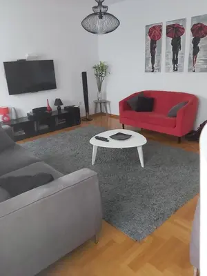 a living room with a red couch and a table at Sky lux apartment Vracar in Belgrade
