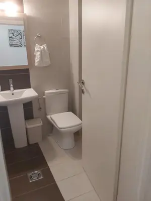 a bathroom with a white toilet and a sink at Sky lux apartment Vracar in Belgrade