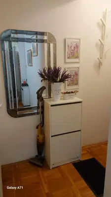 a mirror and a dresser with a guitar in a room at Apartman 