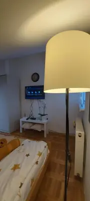a bedroom with a bed and a lamp with stars on it at Apartman 