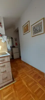 an empty room with a kitchen and a wooden floor at Apartman 