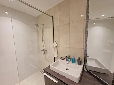 a white bathroom with a sink and a shower at Aqua Royal BW apartment in Sajmište