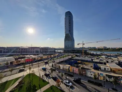 a tall building in the middle of a city at Aqua Royal BW apartment in Sajmište