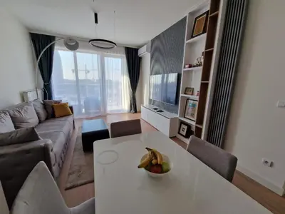 a living room with a table with a bowl of fruit on it at Aqua Royal BW apartment in Sajmište